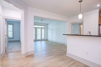 A large, empty room with wooden floors and white walls.