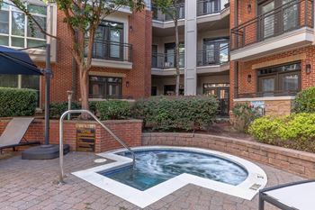 A pool in a courtyard surrounded by buildings.