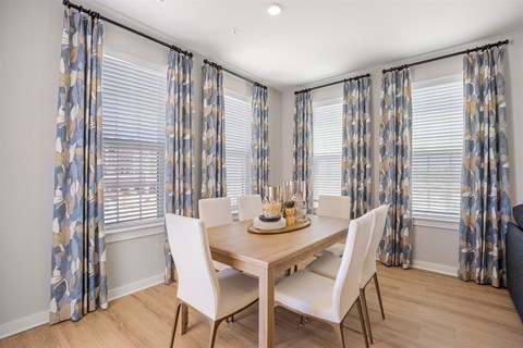 A dining room with a table set for four.