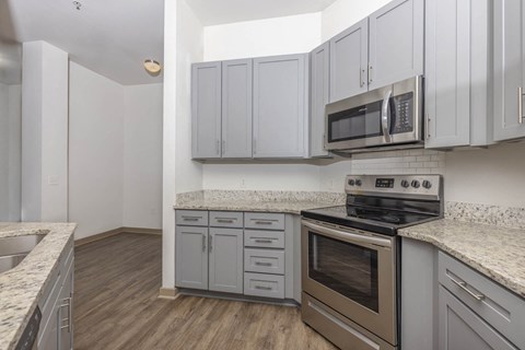 A kitchen with a stove, oven, and cabinets.