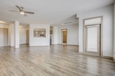A spacious room with a ceiling fan and lighting fixture.