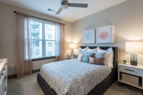 A bedroom with a large bed and a ceiling fan.