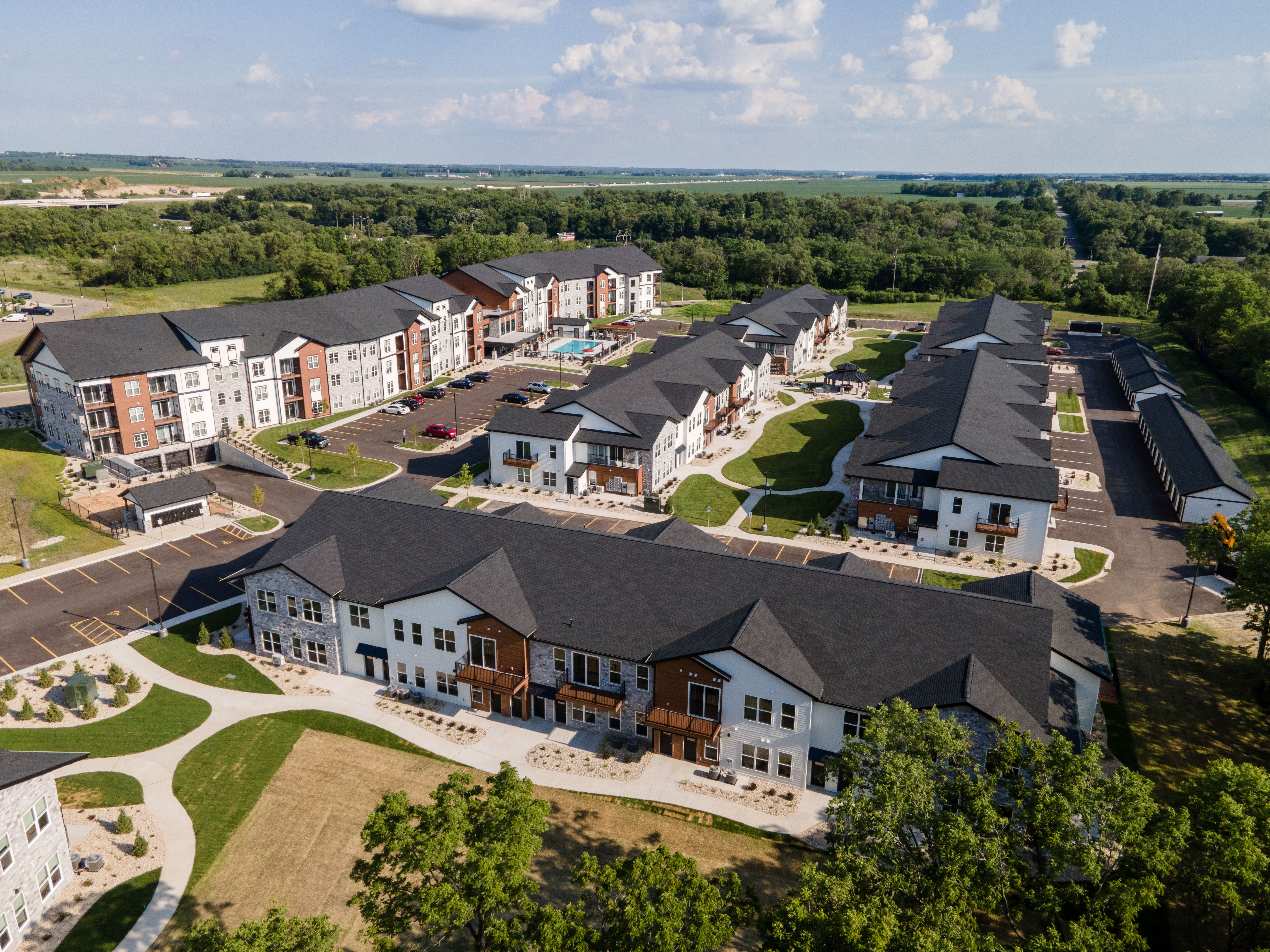 A bird's eye view of a large, well-maintained apartment complex with multiple buildings and green lawns.