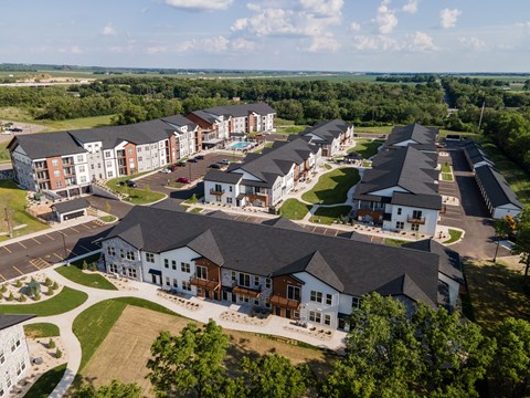 A bird's eye view of a large, well-maintained apartment complex with multiple buildings and green lawns.