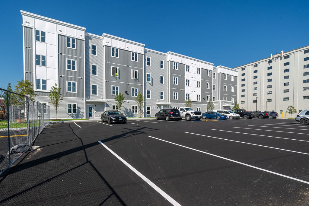 an empty parking lot in front of an apartment building