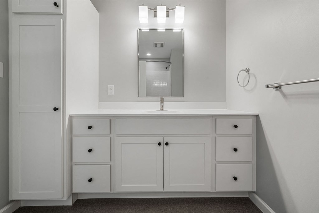 a white bathroom with a sink and a mirror
