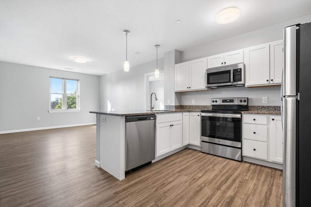 an empty kitchen with white cabinets and stainless steel appliances