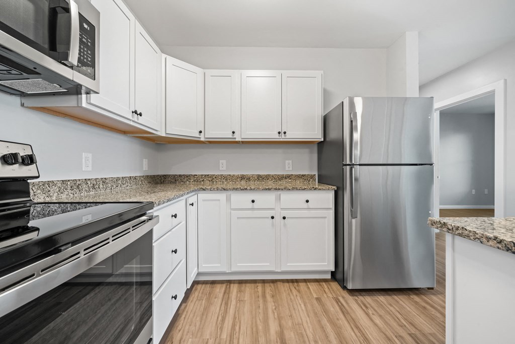 a kitchen with white cabinets and stainless steel appliances
