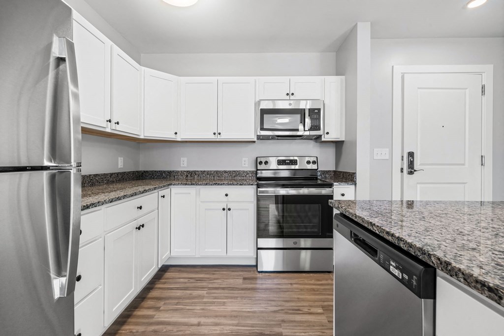 a kitchen with white cabinets and stainless steel appliances