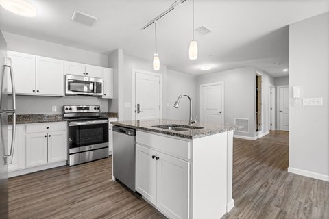 a renovated kitchen with white cabinets and a counter top