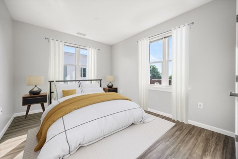 a bedroom with a large bed and two windows