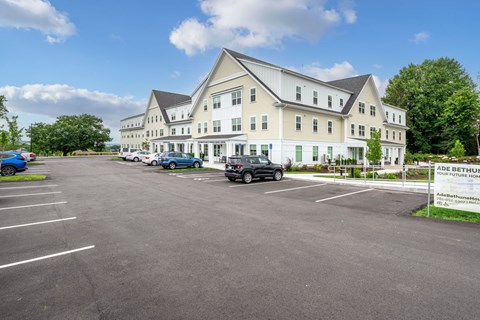 A large white building with a parking lot in front of it.