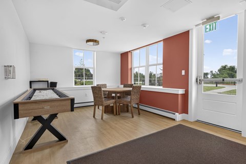 A room with a pool table and a dining table.