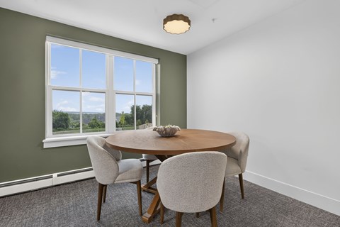 A dining room with a round table and chairs.
