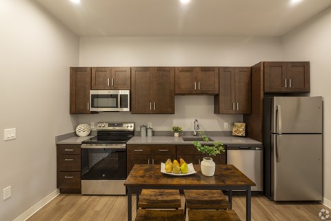 A kitchen with brown cabinets and a wooden table.