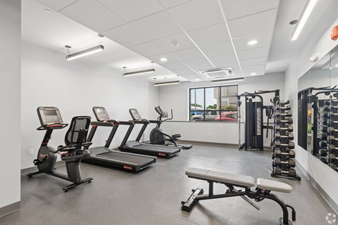 A gym with treadmills, exercise bikes, and weightlifting equipment.