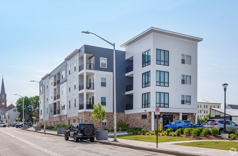 A modern apartment building with a church spire in the background.