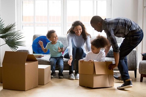 a family of four unpacking boxes in a living room
