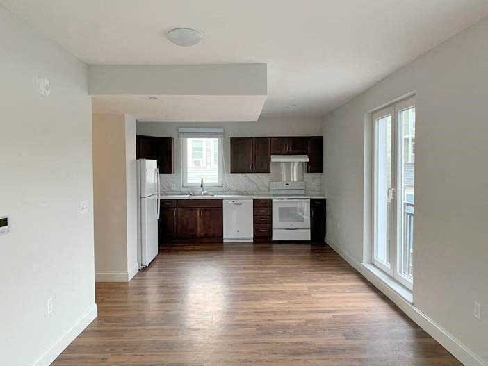 Interior Kitchen and Livingroom Modern plank flooring, large bright windows, open floor plan.