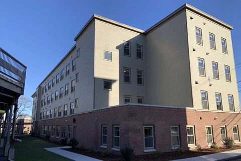 A large building with a flat roof and a smaller one with a sloped roof.