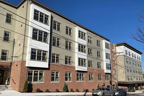 A multi-story building with a mix of brick and siding exterior.