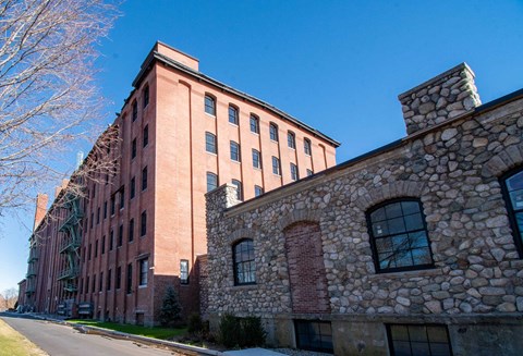 A tree-lined alley runs behind the building
