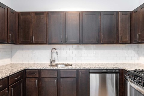 a kitchen with dark wood cabinets and a granite counter top