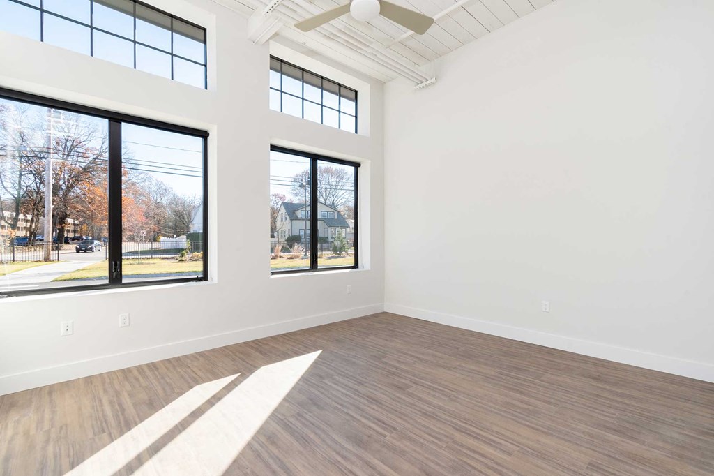 Modern plank flooring, oversized windows, high ceilings with exposed loft features