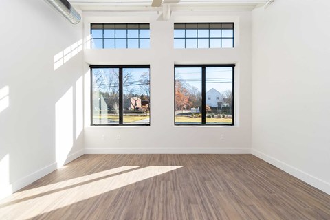 Modern plank flooring, oversized windows, high ceilings with exposed loft features