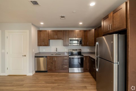 A modern kitchen with wooden cabinets and stainless steel appliances.