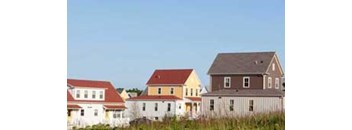 A row of houses with different colored roofs.