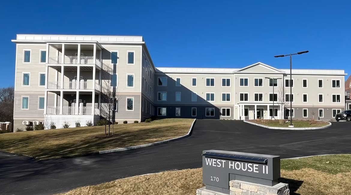 A large white building with a sign that says West House II.
