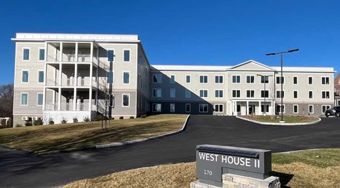 A large white building with a sign that says West House II.