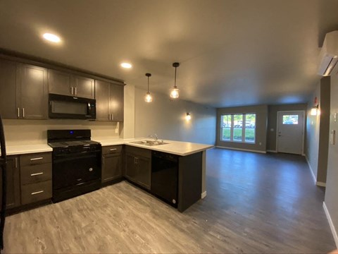 A kitchen with dark wood cabinets and a black stove top oven.