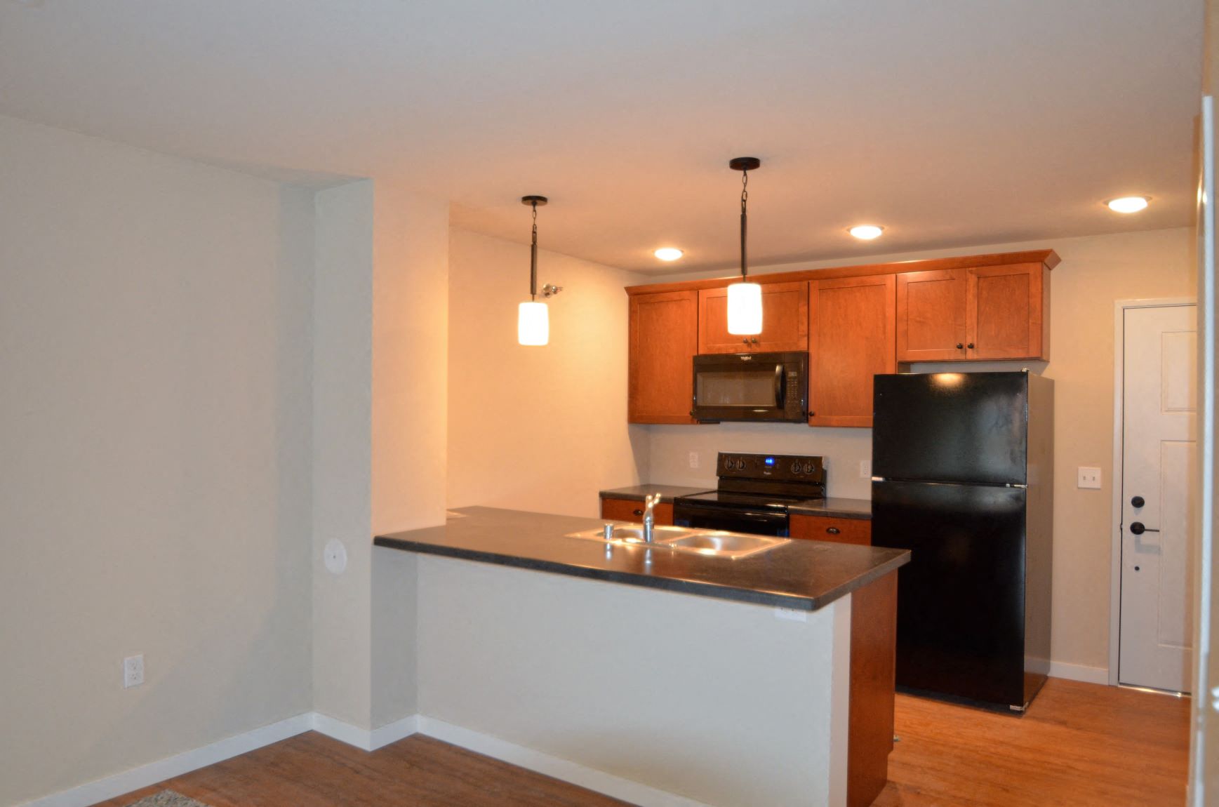a kitchen with an island and a black refrigerator