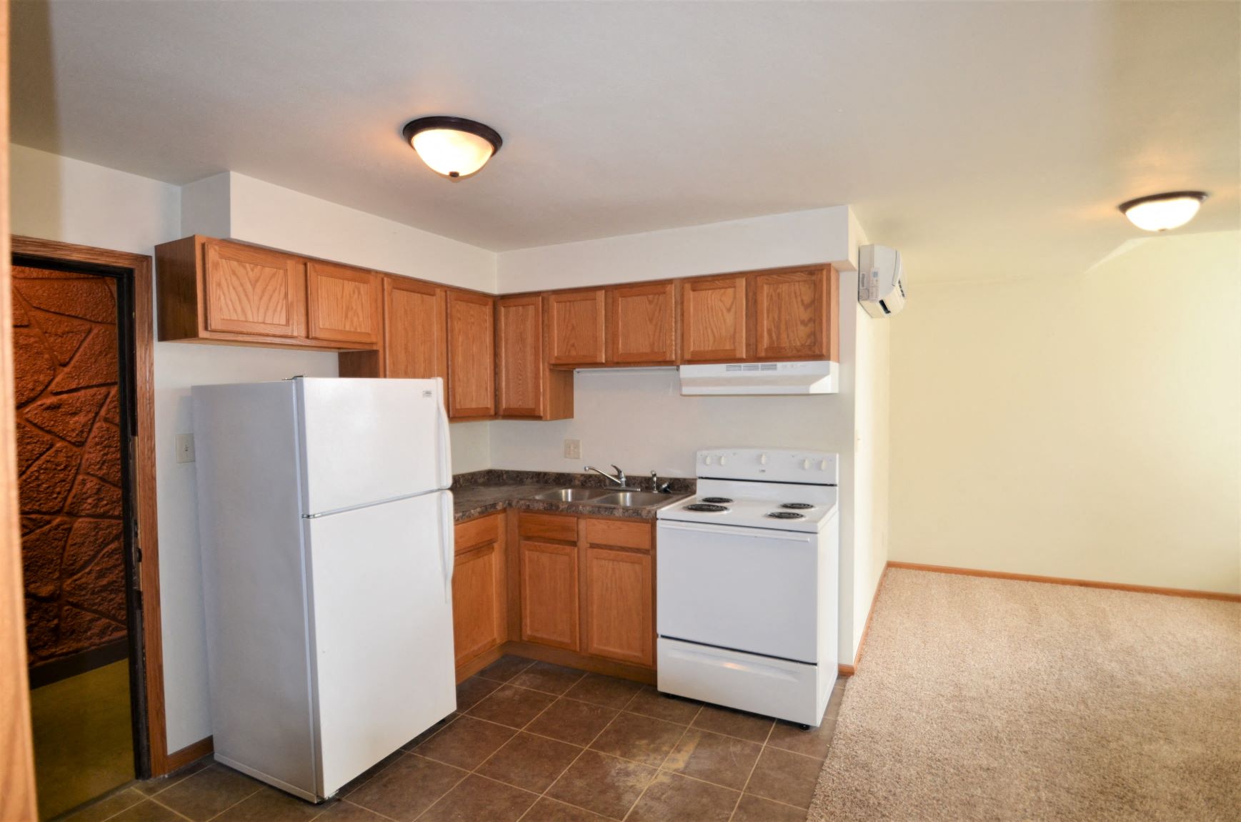 a kitchen with white appliances and wooden cabinets