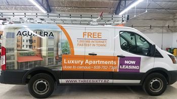 the side of a van with a free luna apartments sign on it