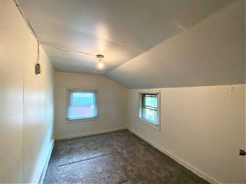 the living room of a house with white walls and a carpet