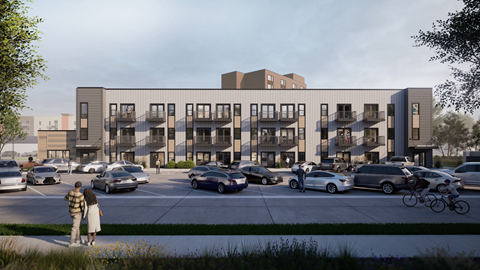 A modern apartment complex with cars parked in front.