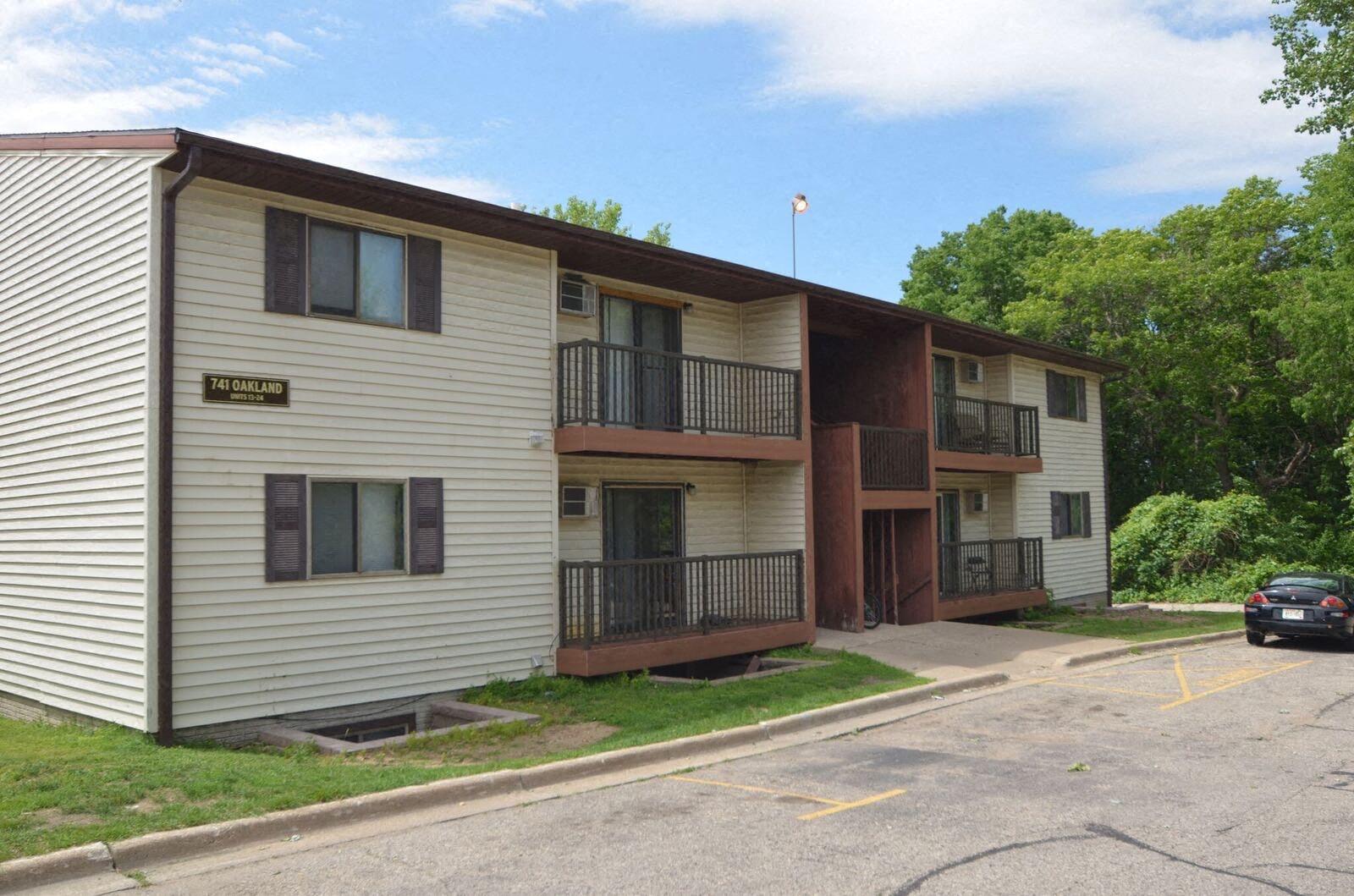 A small apartment complex with a car parked in front.
