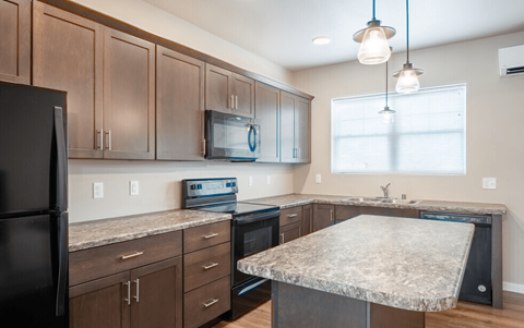 a kitchen with granite counter tops and wooden cabinets