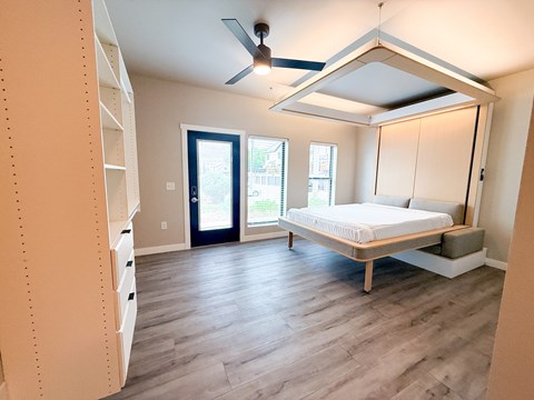 A bedroom with a bed, dresser, and window.