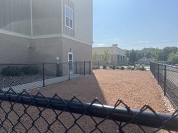 a chain link fence in front of a building with a dog run