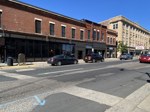 a city street with cars parked in front of a building
