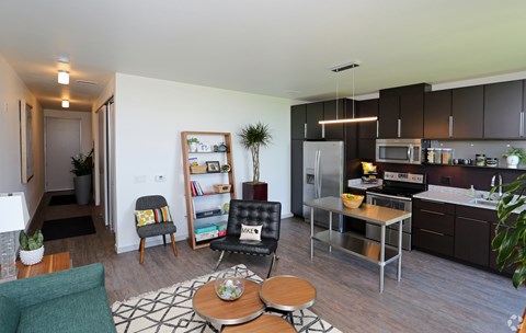 A modern kitchen with a dining table and chairs in the middle of the room.