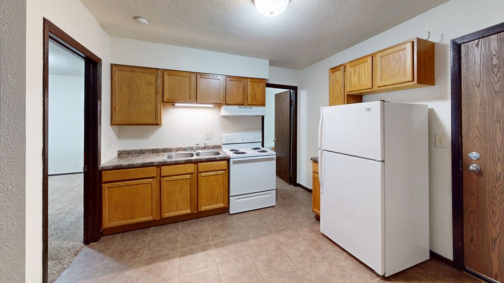 A kitchen with wooden cabinets and a white refrigerator.
