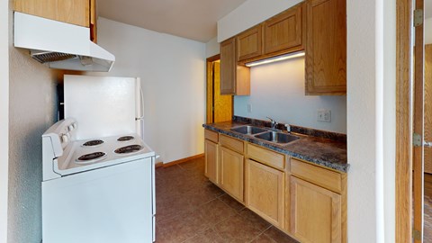 A kitchen with a white stove and wooden cabinets.