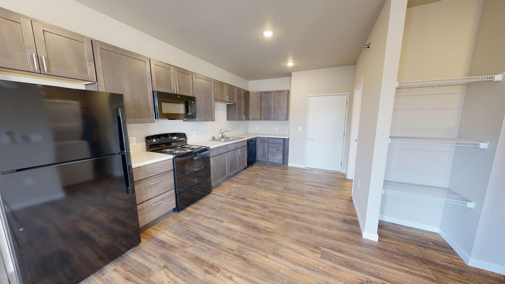 a kitchen with wood flooring and stainless steel appliances and