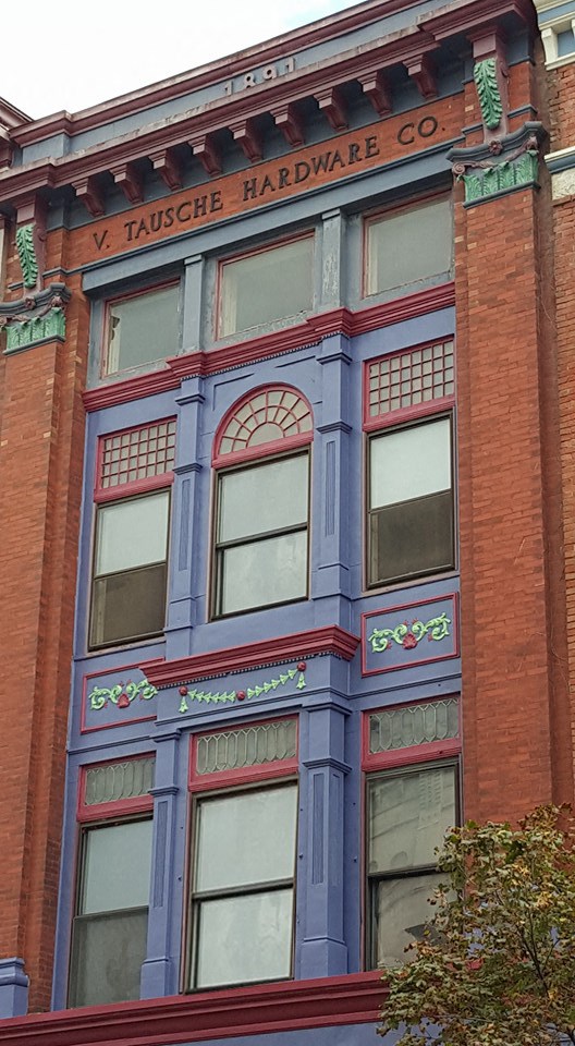 a tall building with a blue facade and windows