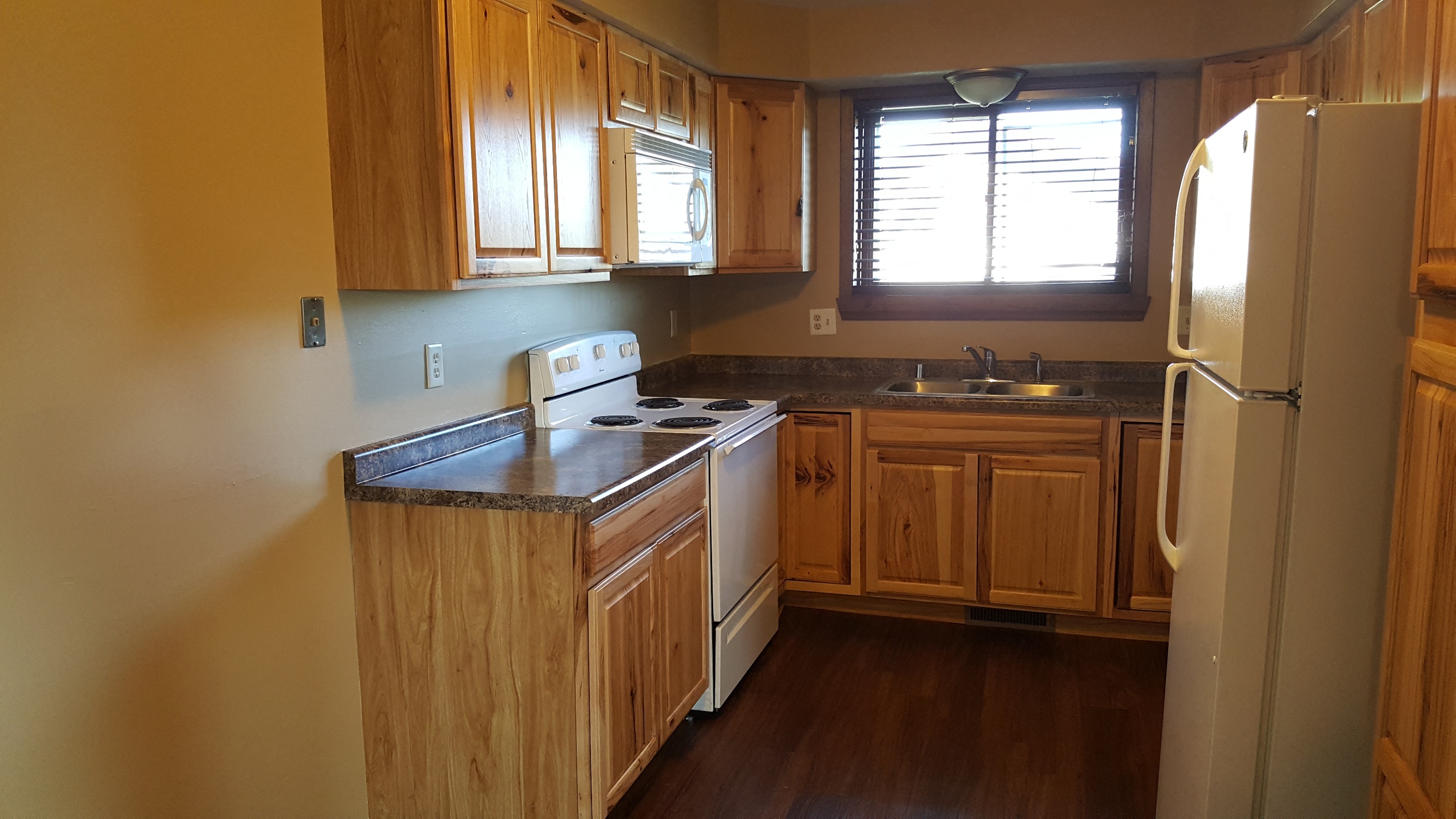 a kitchen with wooden cabinets and a white refrigerator